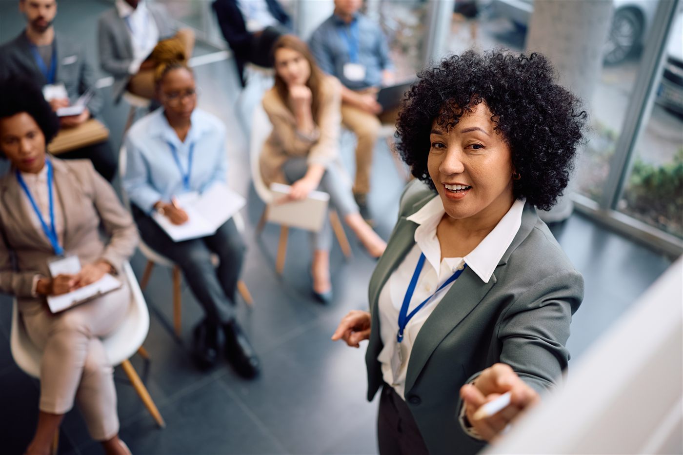 Facilitadora conduzindo treinamento para um grupo diverso de profissionais